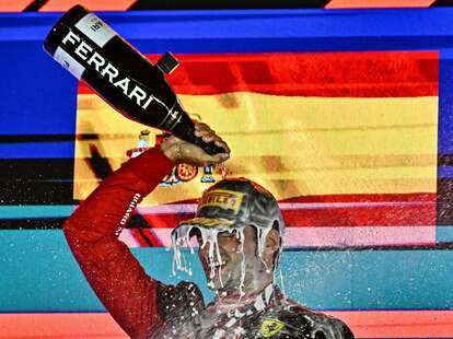 Carlos Sainz Jr pours champagne on himself as he celebrates on the podium after winning the Singapore Formula One Grand Prix.