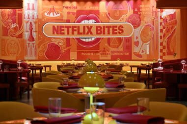 The interior of the restaurant is awash in the streaming platform's signature red, with splashes of orange and yellow in the forms of task lighting and curved-back armchairs.